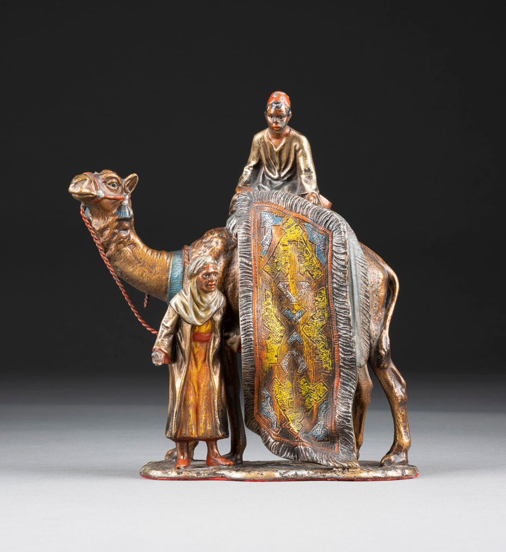 CARL KAUBA | TEPPICHHÄNDLER AUF KAMEL UND BEDUINE: CARL KAUBA 1865 Wien - 1922 ebenda TEPPICHHÄNDLER AUF KAMEL UND BEDUINE Metallguss, polychrom gefasst. H. 18,5, B. 16, T. 6,5 cm, Gew. ca. 0,93 kg.. Part. ber.CARL KAUBA TEPPICHHÄNDLER AUF KAMEL UND