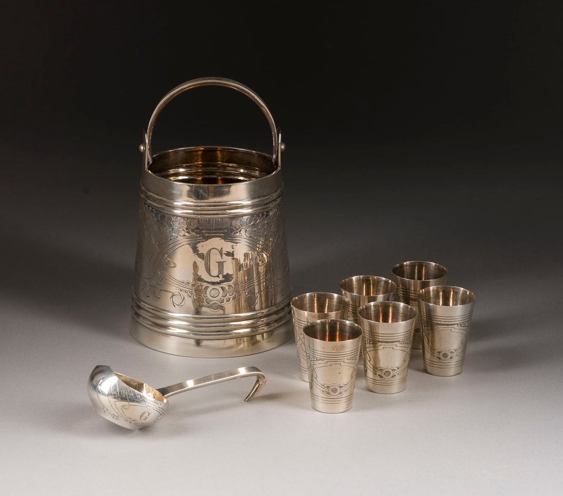 | SELTENES ACHTTEILIGES WODKA-TRINKSET: A SILVER VODKA BUCKET, LADLE AND SIX BEAKERS EN SUITE Russian, Moscow, Nikolay Ivanov, 1908-1917 The swing-handled bucket engraved with geometric motifs. Marked with assayer's mark, 84 standard and