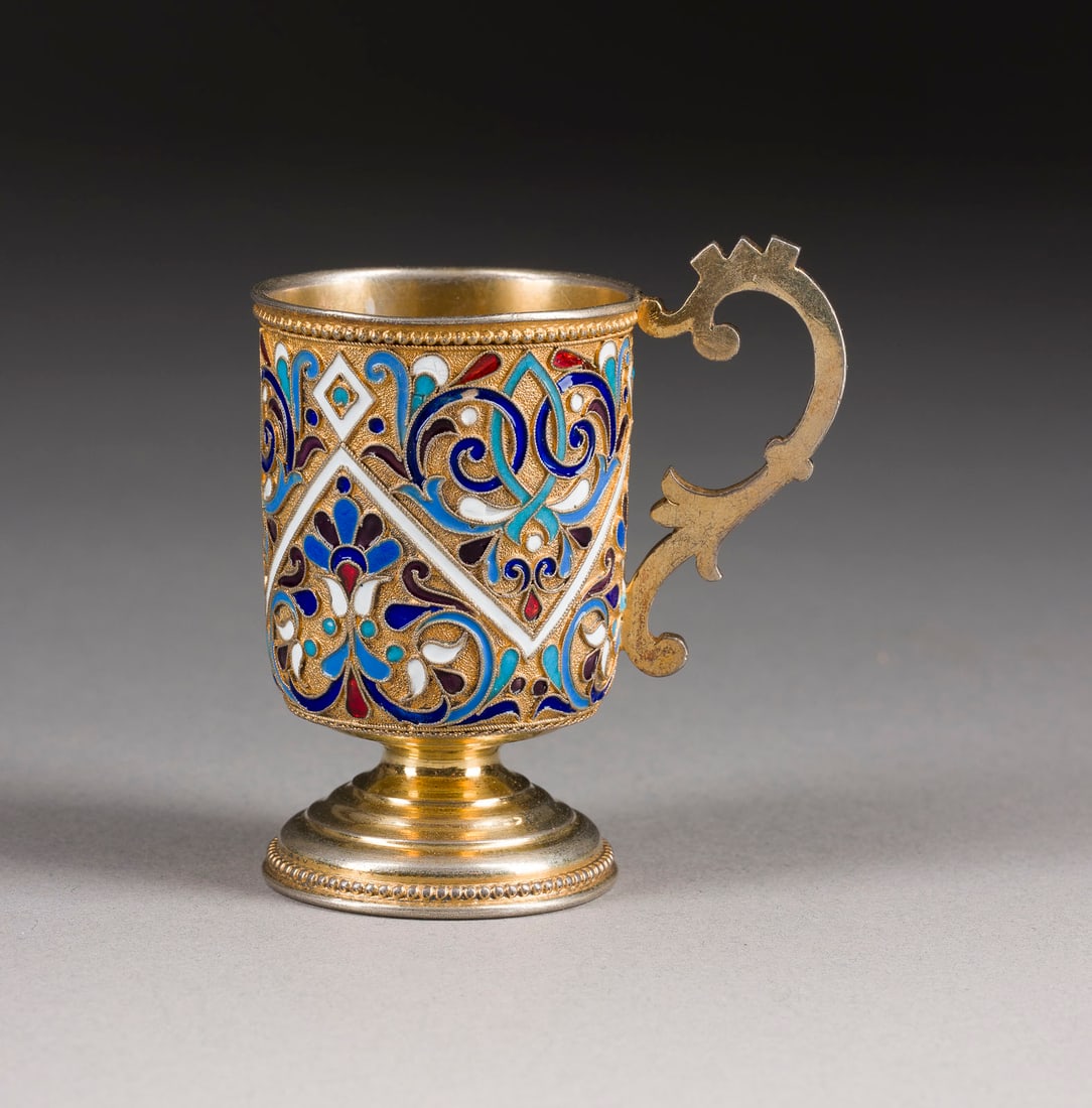 | CLOISONNE-EMAIL-HENKELBECHER: A SILVER-GILT AND CLOISONNE ENAMEL CUP WITH HANDLE Russian, Moscow, Gustav Klingert, 1889 The cylindrical body decorated with scrolling foliage on stippled ground. Marked with city hallmark, assayer's
