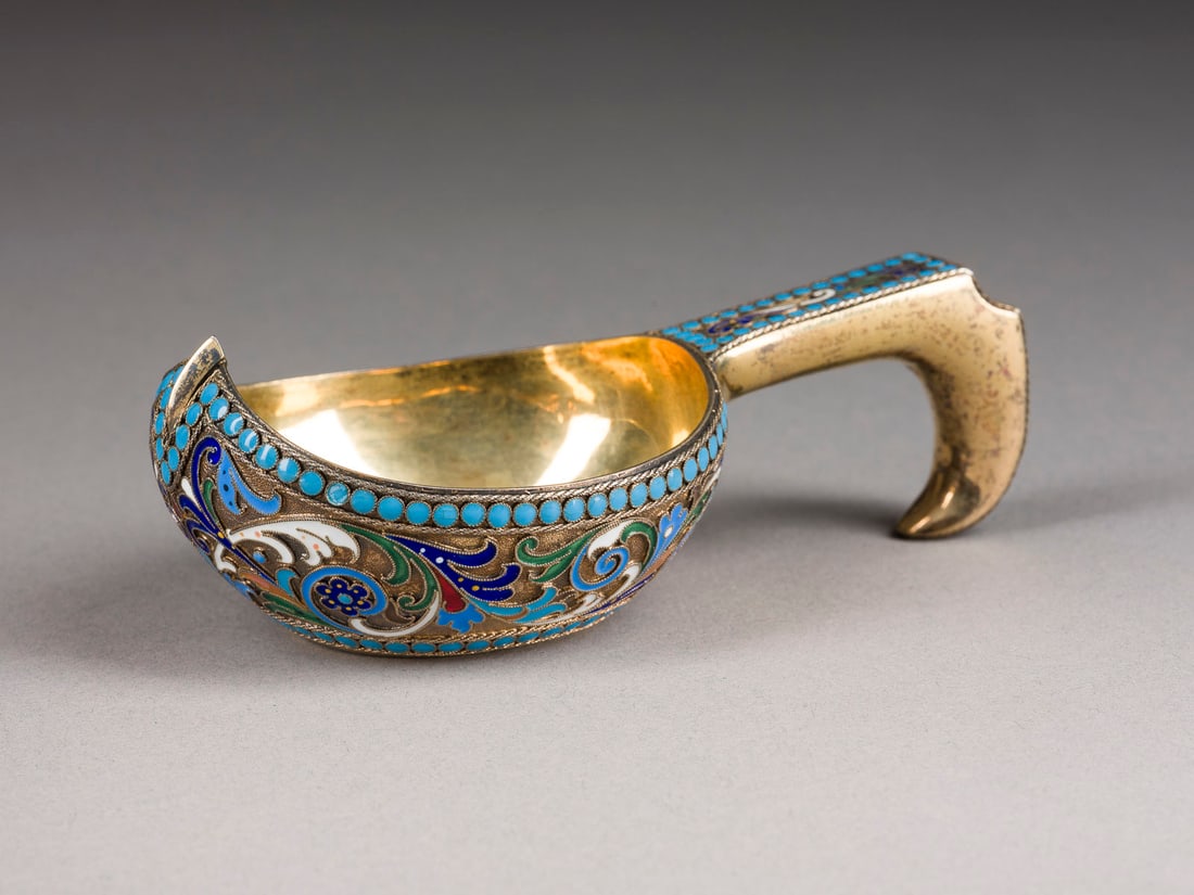 | CLOISONNE-EMAIL-KOWSCH: A SILVER-GILT AND CLOISONNE ENAMEL KOVSH Russian, St. Petersburg, Lyubavin, 1896-1908 Of traditional form, with brightly coloured, stylized flowers against a stippled gilt ground, the hook handle