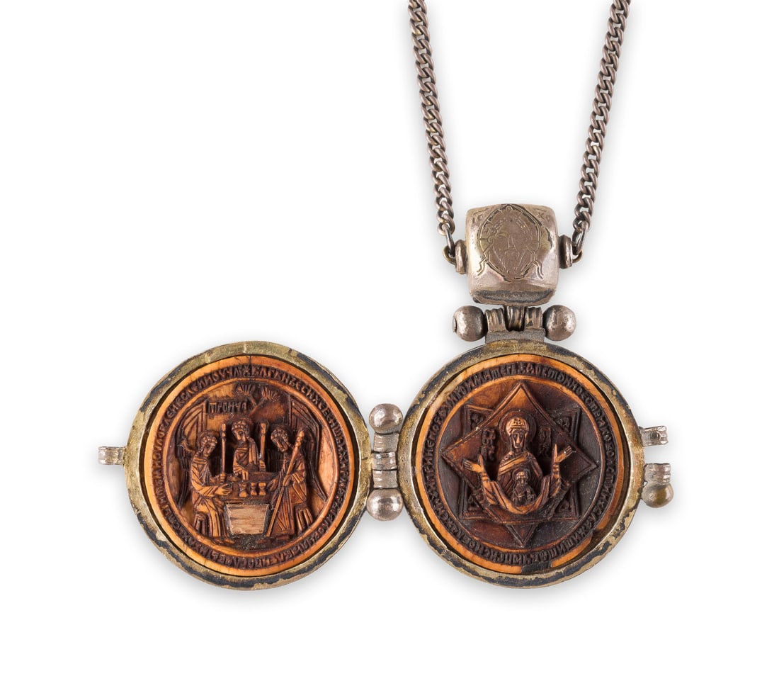 | SEHR FEINE PANHAGIA MIT DER KREUZIGUNG, DER ALTTESTAMENTLICHEN DREIFALTIGKEIT, DER GOTTESMUTTER: A VERY FINE METAL-GILT PANHAGIA SHOWING THE CRUCIFIXION, THE MOTHER OF GOD OF THE SIGN, THE OLD TESTAMENT TRINITY AND THREE SAINTS Russian, 16th century Metal-gilt filigree body, bone carved in miniat