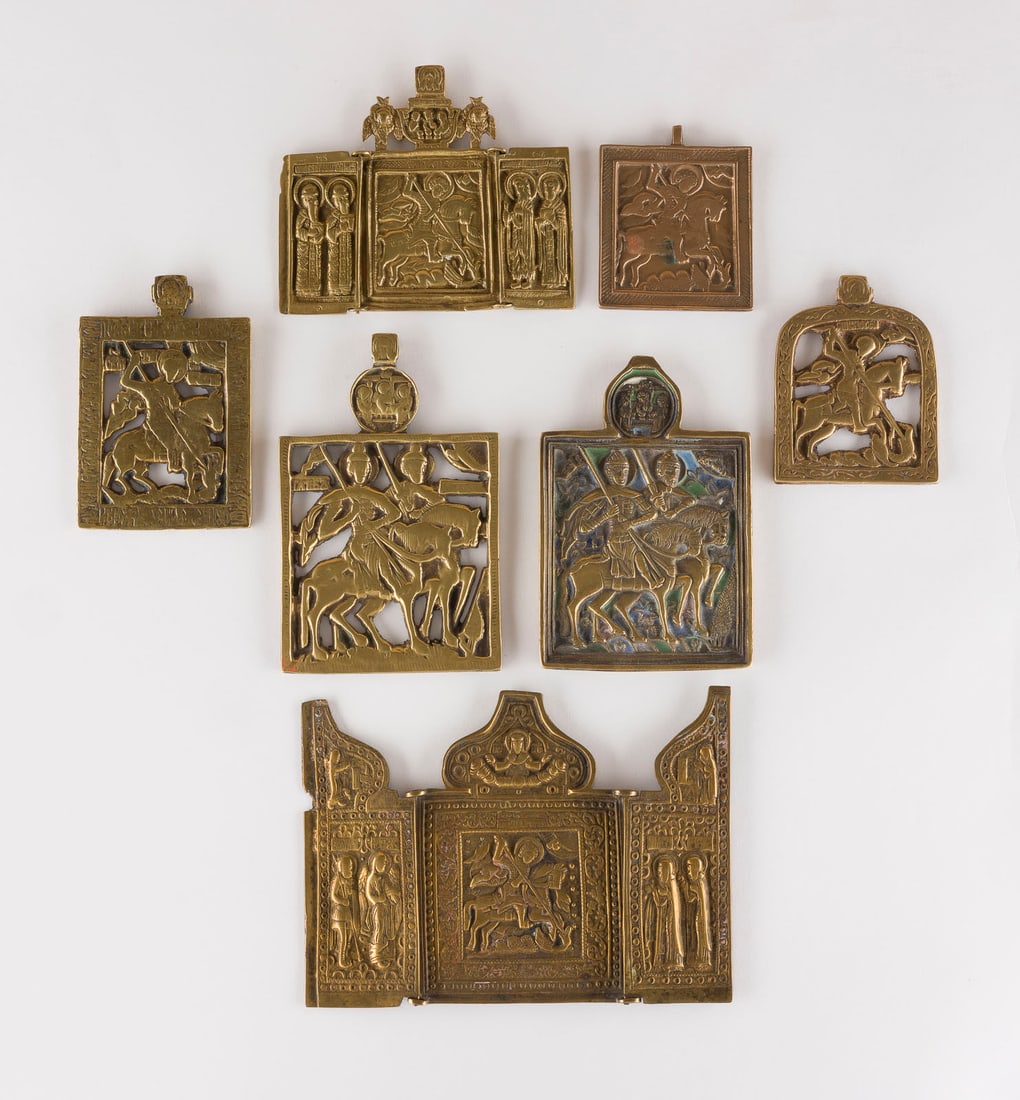 | SAMMLUNG VON SIEBEN BRONZE-IKONEN: HEILIGE BORIS UND GLEB SOWIE HEILIGER GEORG DER DRACHENTOeTER: A COLLECTION OF SEVEN BRASS ICONS DEPICTING STS. BORIS AND GLEB AS WELL AS ST. GEORGE KILLING THE DRAGON Russian,17th-19th century Cast in relief, partially four-colour enamelled. Enamel part. chipped