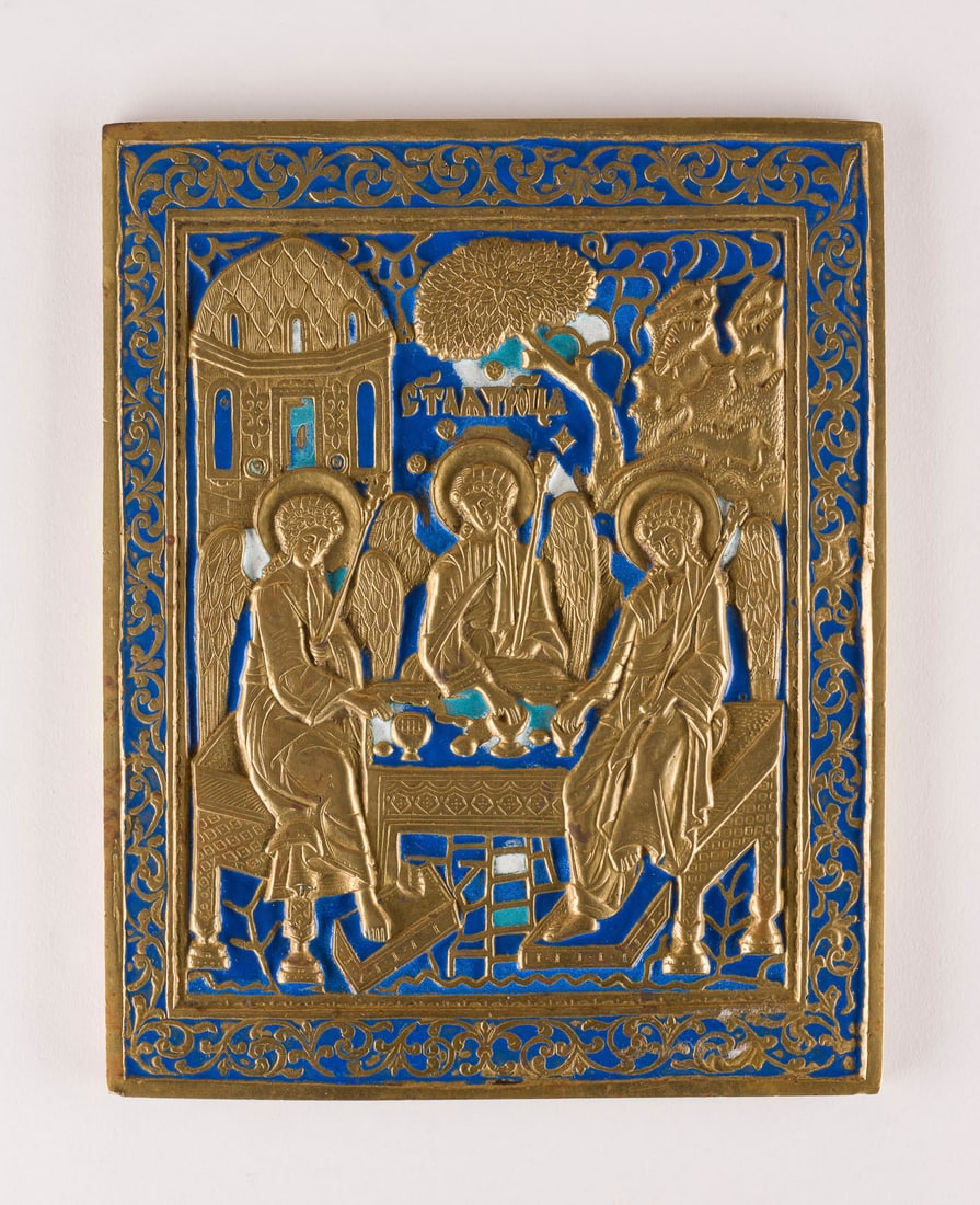 | BRONZE-IKONE MIT DER ALTTESTAMENTLICHEN DREIFALTIGKEIT: A BRASS AND ENAMEL ICON SHOWING THE OLD TESTAMENT TRINITY Russian, 19th century Cast in relief, three-colour enamelled. Enamel min. chipped. 20.6 cm high.BRONZE-IKONE MIT DER ALTTESTAMENTLICHEN DREIFA