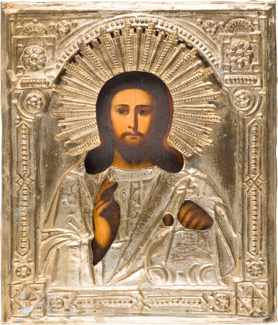 | IKONE MIT CHRISTUS PANTOKRATOR MIT OKLAD: AN ICON SHOWING CHRIST PANTOKRATOR WITH OKLAD Russian, 19th century Oil on wood panel with cloth backing. Overlaid with a chased brass oklad. 30.8 x 26.5 cm.IKONE MIT CHRISTUS PANTOKRATOR MIT OKLAD Ru