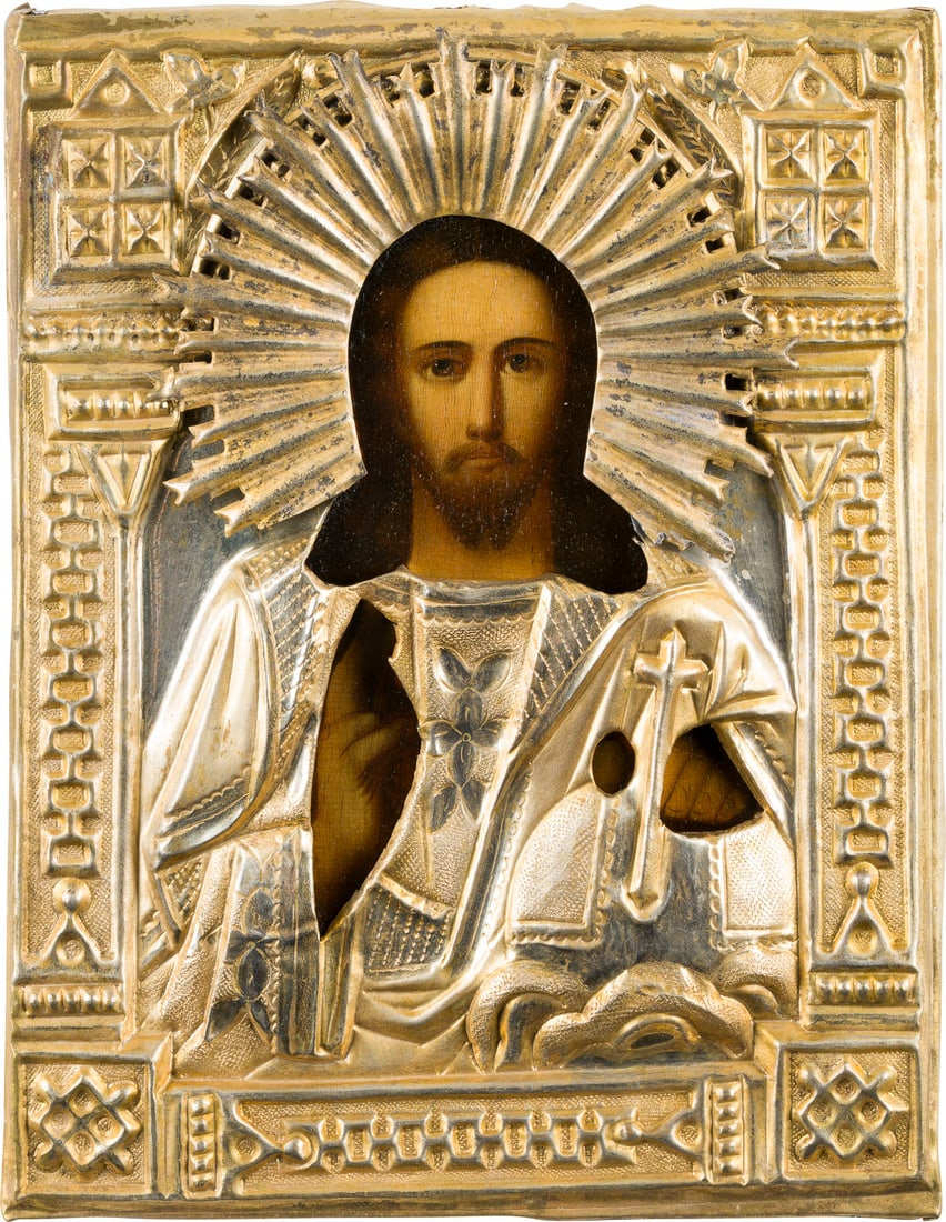 | KLEINE IKONE MIT CHRISTUS DEM WELTENHERRSCHER MIT OKLAD: A SMALL ICON SHOWING CHRIST THE SAVIOUR WITH OKLAD Russian, 19th century Oil on wood panel with cloth backing. The brass oklad chased and repousse. 22.3 x 17.2 cm.KLEINE IKONE MIT CHRISTUS DEM WELTENH