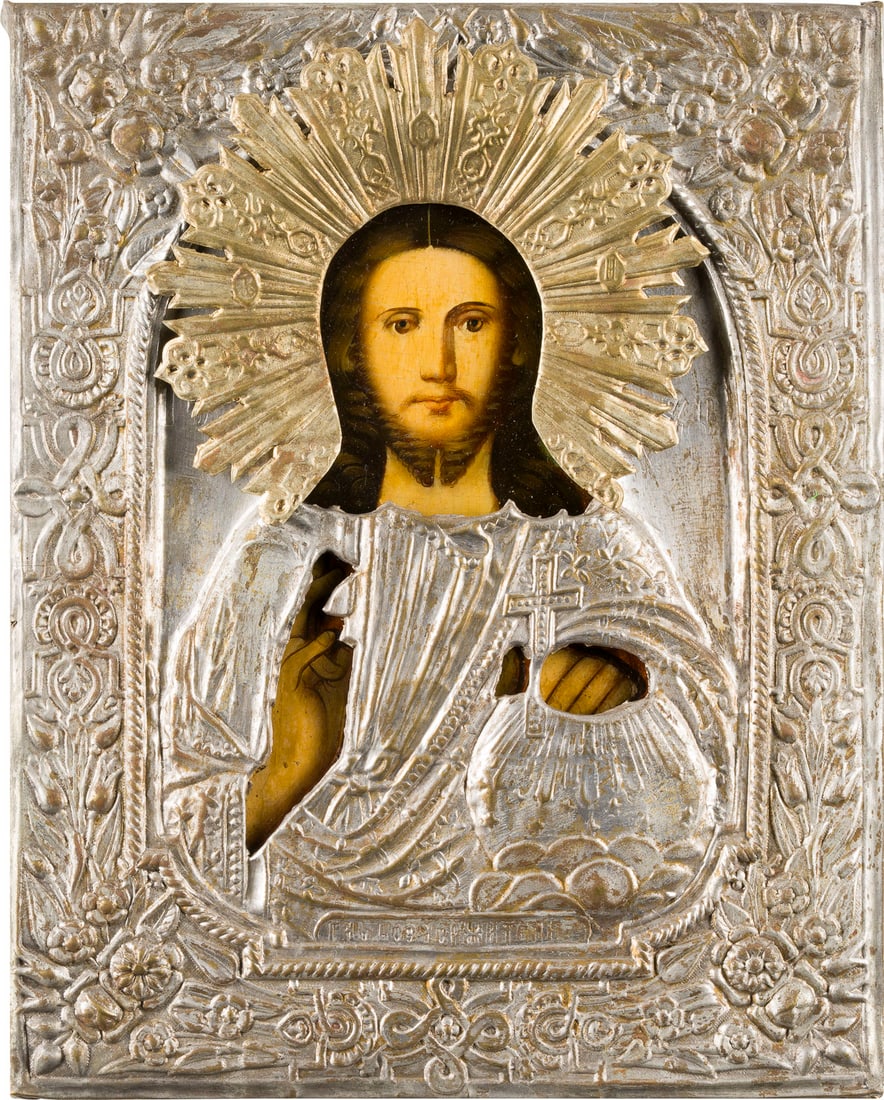 | KLEINE IKONE MIT CHRISTUS DEM WELTENHERRSCHER MIT OKLAD: A SMALL ICON SHOWING CHRIST THE SAVIOUR WITH OKLAD Russian, 2nd half of the 19th century Oil on wood panel. The brass oklad chased and embossed. 22.4 x 17.6 cm.KLEINE IKONE MIT CHRISTUS DEM WELTENHERR
