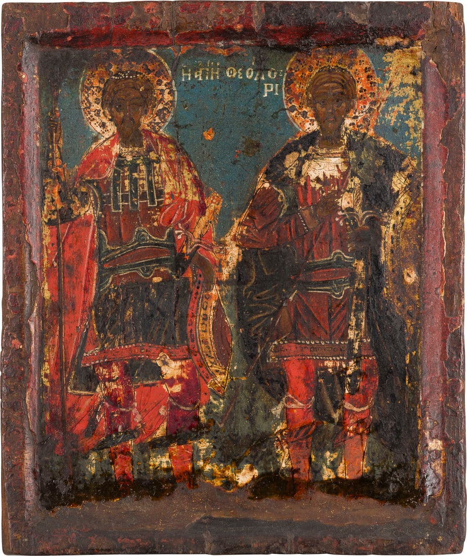 | KLEINE IKONE MIT DEN HEILIGEN THEODOR TIRON UND THEODOR STRATELATES: A SMALL ICON SHOWING STS. THEODORE TYRON AND THEODORE STRATELATES Greek, early 18th century Tempera on wood panel with kovcheg. The garments with gold highlights. Losses, the lower border restored. 22