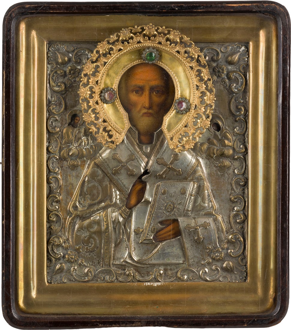| GROSSE IKONE MIT DEM HEILIGEN NIKOLAUS VON MYRA MIT OKLAD IM KIOT: A LARGE ICON SHOWING ST. NICHOLAS OF MYRA WITH OKLAD WITHIN KYOT Russian, mid 19th century Oil on wood panel. With repousse, chased and engraved floral scroll metal oklad. The applied halo set with pa
