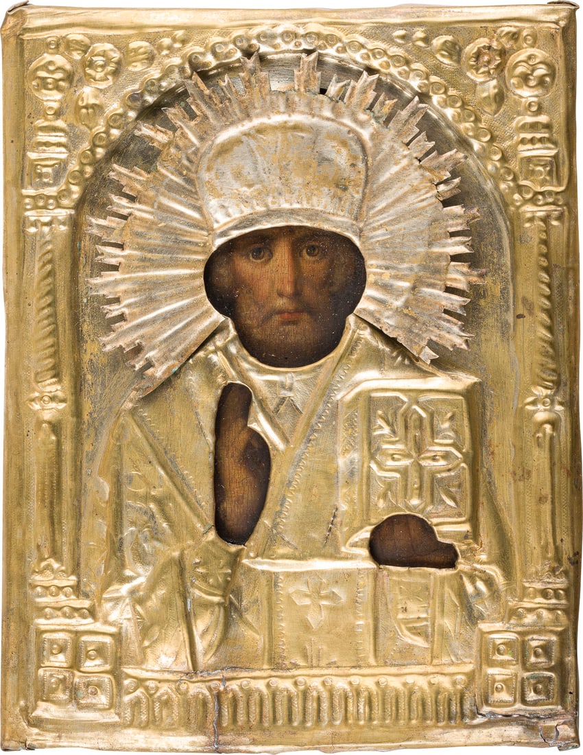 | KLEINE IKONE MIT DEM HEILIGEN NIKOLAUS VON MYRA MIT OKLAD: A SMALL ICON SHOWING ST. NICHOLAS OF MYRA WITH OKLAD Russian, 19th century Oil on wood panel. The brass oklad chased and repousse. Minor damages to the oklad. 22.2 x 17.4 cm.KLEINE IKONE MIT DEM HEILI