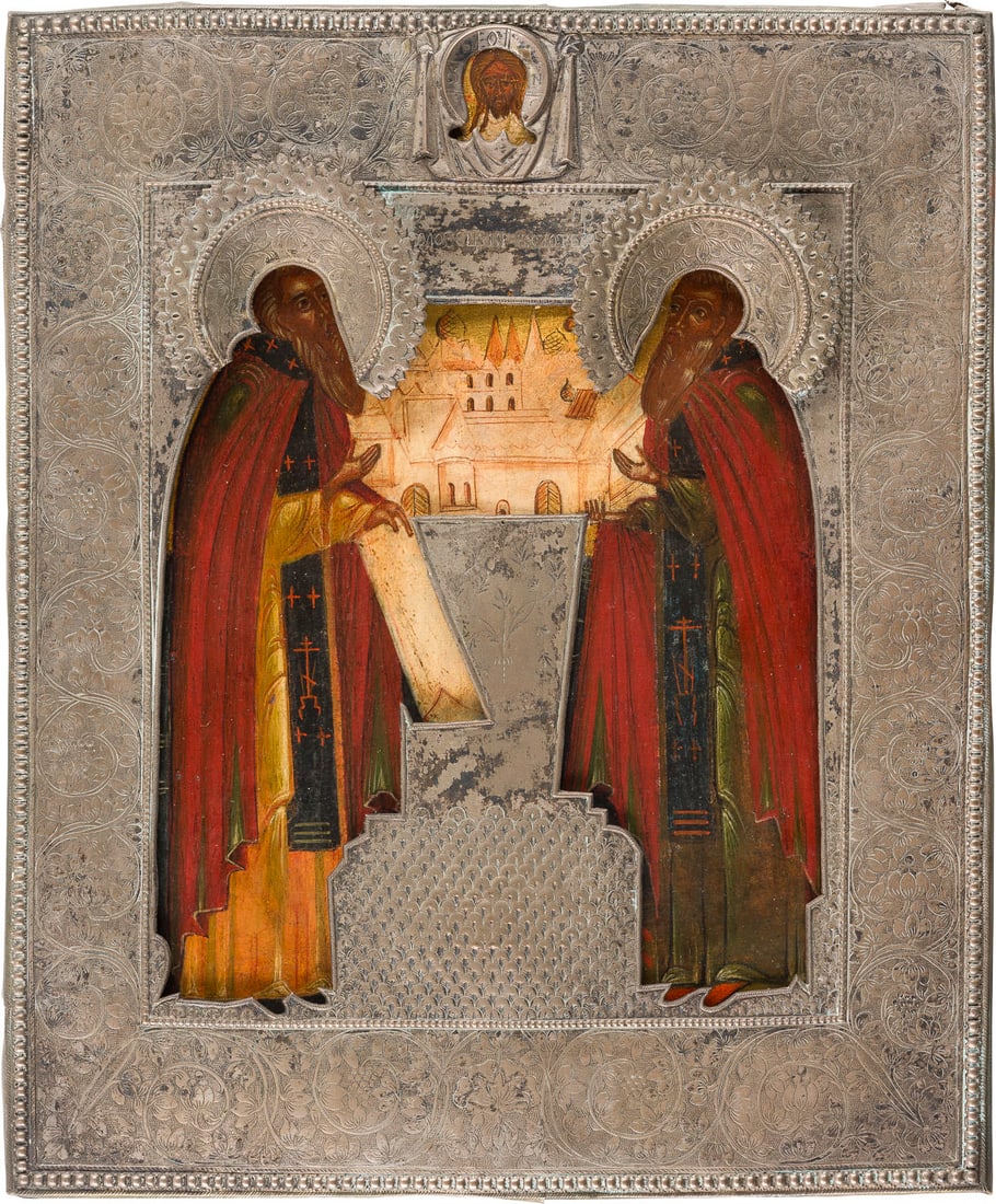 | IKONE MIT DEN HEILIGEN KLOSTERGRUeNDERN ZOSIMA UND SAWATIJ MIT RIZA: AN ICON SHOWING STS. ZOSIMA AND SAVATIY WITH RIZA Russian, 18th century Tempera on wood panel. The background made of gold. The metal riza engraved with scrolling foliage. Partially restored. 31.7 x 2