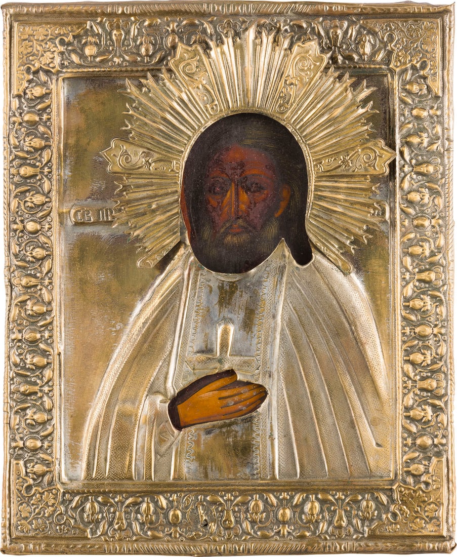 | KLEINE IKONE MIT DEM HEILIGEN SERAFIM VON SAROW MIT OKLAD: A SMALL ICON SHOWING ST. SERAPHIM OF SAROV WITH OKLAD Russian, after 1903 Tempera on wood panel. Overlaid with a chased brass oklad. Restored. 26 x 21.5 cm.KLEINE IKONE MIT DEM HEILIGEN SERAFIM VON SA