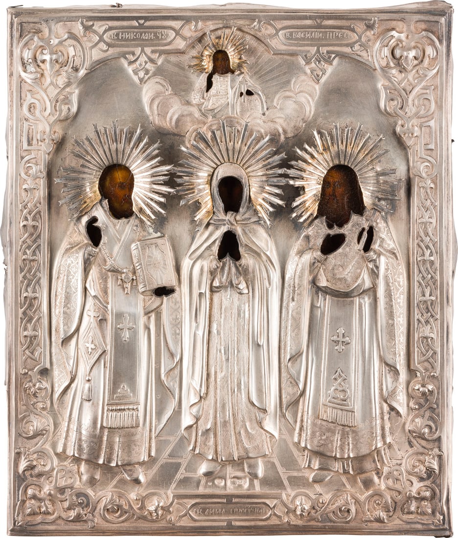 | IKONE MIT DER HEILIGEN ANNA, DER PROPHETIN, FLANKIERT VON DEN HEILIGEN NIKOLAUS VON MYRA UND: AN ICON SHOWING ST. ANNA THE PROPHETESS FLANKED BY STS. NICHOLAS OF MYRA AND BASIL THE GREAT WITH SILVER OKLAD Russian, circa 1880 (icon), Russian, Moscow, circa 1880 (oklad) Oil on wood panel. The si