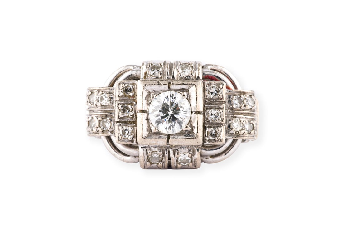 ART DECO RING: ART DECO RING WG 585. Ringmass: ca. 57. Ges.-Gew.: ca. 6,5 g. Ring, besetzt mit einem zentralen Diamanten im Altschliff von ca. 0.32 ct. G/SI, sowie weiterer Besatz aus Diamanten im 8/8-Schliff zus.