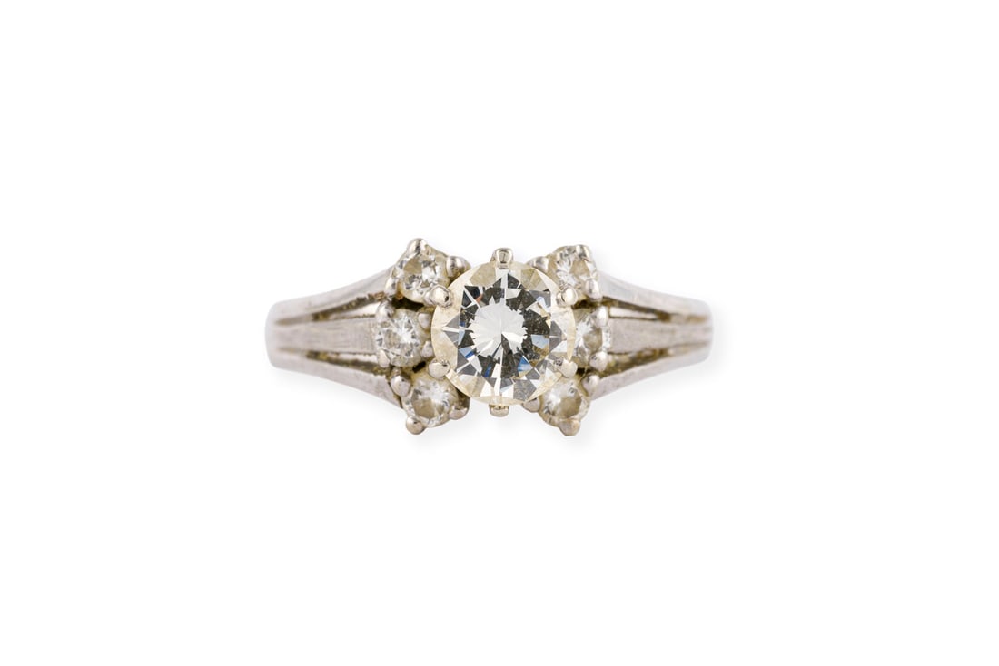 BRILLANT RING: BRILLANT RING WG 585. Ringmass: ca. 50. Ges.-Gew.: ca. 3,3 g. Ring, besetzt mit einem zentralen Brillanten von ca. 0.60 ct. H/VVS, flankiert von insg. 6 weiteren Brillanten zus. ca. 0.18 ct.