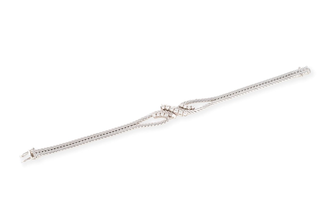 SCHWUNGVOLLES BRILLANT ARMBAND: SCHWUNGVOLLES BRILLANT ARMBAND WG 585. L.: ca.18,5 cm. B.: ca. 12,7 mm. Ges.-Gew.: ca. 18,7 g. Armband, besetzt mit Brillanten zus. ca. 0.68 ct. F-G/VVS-VS. Kastenschloss mit Sicherheitsacht.