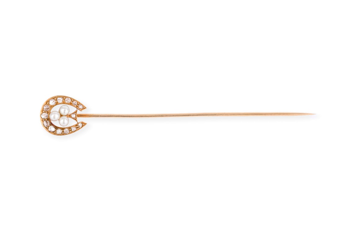 HUFEISEN STECKNADEL: HUFEISEN STECKNADEL GG 750 (getestet). Masse: 87,0 x 12,7 mm. Ges.-Gew.: ca. 3,8 g. Stecknadel mit Hufeisen, besetzt mit Perlen und Rosendiamanten zus. ca. 0.20 ct.