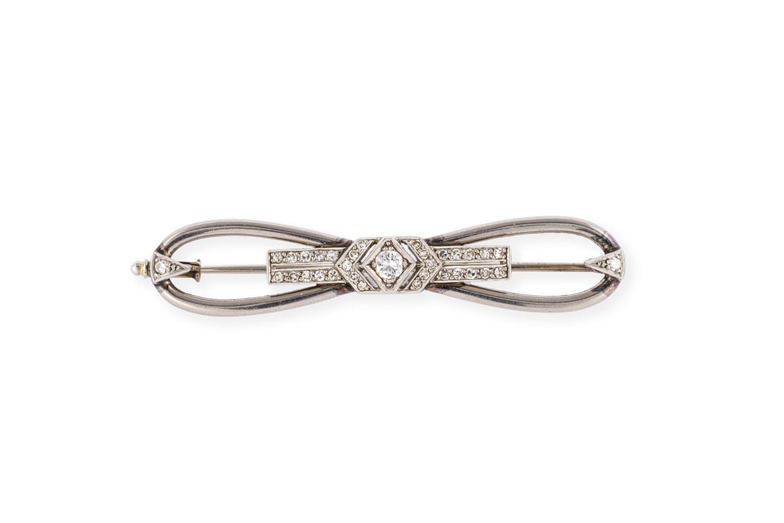 ART DECO SCHLEIFEN BROSCHE: ART DECO SCHLEIFEN BROSCHE PT/GG 333 (getestet). Masse: ca. 54,0 x 11,0 mm. Ges.-Gew.: ca. 5,9 g. Brosche, besetzt mit Diamanten zus. ca. 0.25 ct.
