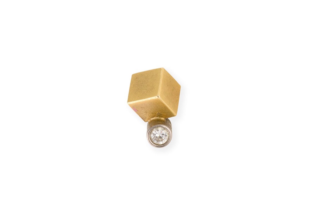 NIESSING' WUERFEL ANHAENGER: NIESSING' WUERFEL ANHAENGER WG/GG 750. Masse: ca. 10,0 x 5,3 mm. Ges.-Gew.: ca. 2,3 g. Anhaenger in Wuerfelform von 'Niessing', besetzt mit einem Brillanten von ca. 0.05 ct.