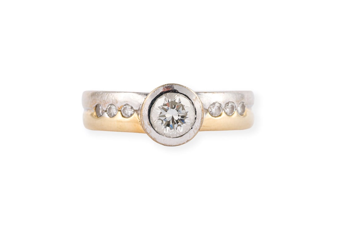BICOLOR BRILLANT RING: BICOLOR BRILLANT RING WG/GG 585. Ringmass: ca. 56. Ringbreite: ca. 7,7 mm. Ges.-Gew.: ca. 7,8 g. Bicolor Ring, besetzt mit einem zentralen Brillanten von ca. 0.67 ct. I/VVS, sowie insg. 6 kleine Brill