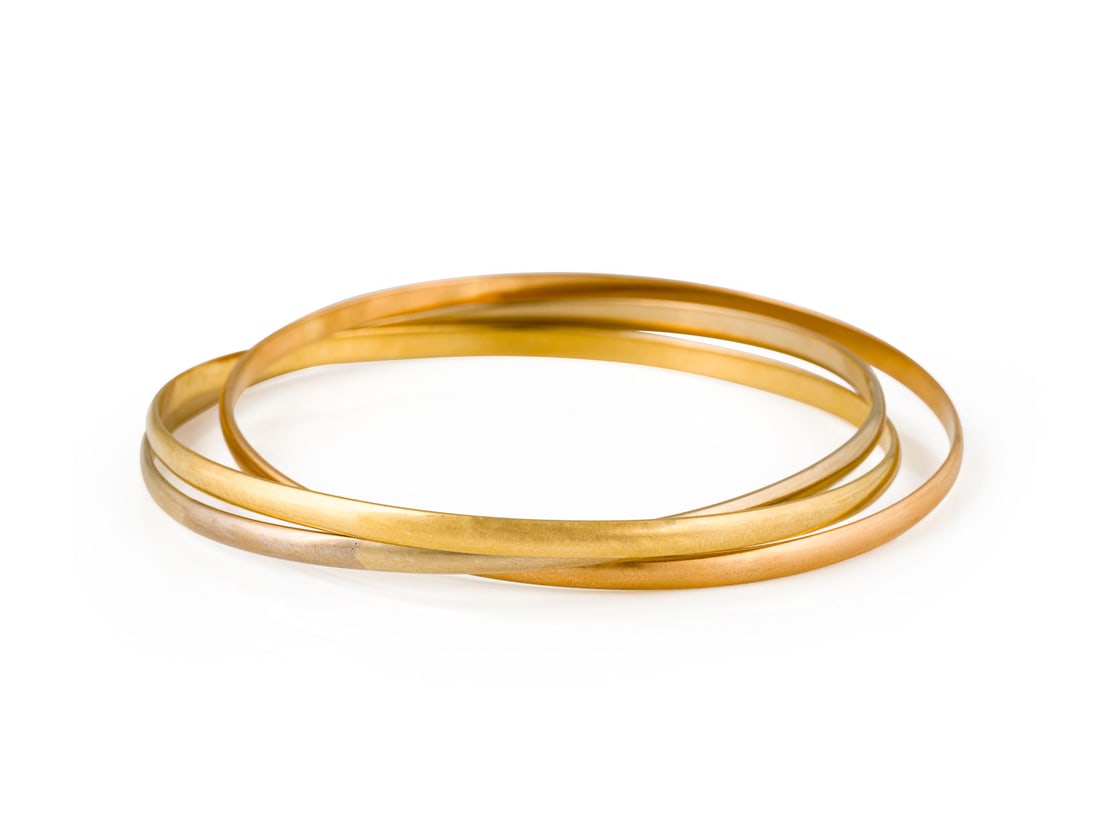 TRINITY DE 'CARTIER' ARMREIF: TRINITY DE 'CARTIER' ARMREIF WG/GG/RG 750. Groesse: 64. Ges.-Gew.: ca. 36,4 g. Trinity de Cartier Armreifen. Tricolor. Expertise: inkl. Original-Zertifikat von Cartier.