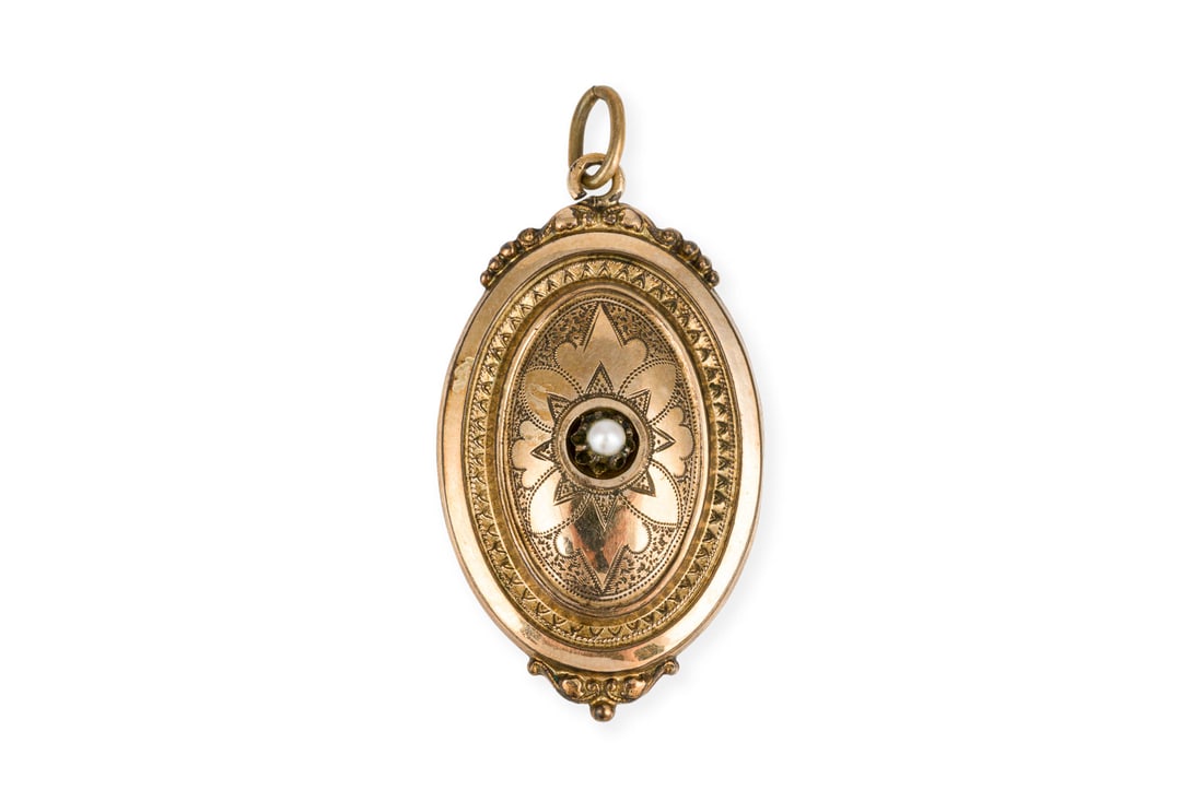 TRAUERSCHMUCK ANHAENGER 19. JH.: TRAUERSCHMUCK ANHAENGER 19. JH. GG 333 (getestet). Masse: ca. 47,7 x 24,5 mm. Ges.-Gew.: ca. 5,1 g. fein ziselierter Medaillon mit einer kleinen zentralen Perle auf der Frontseite. Haarlocke