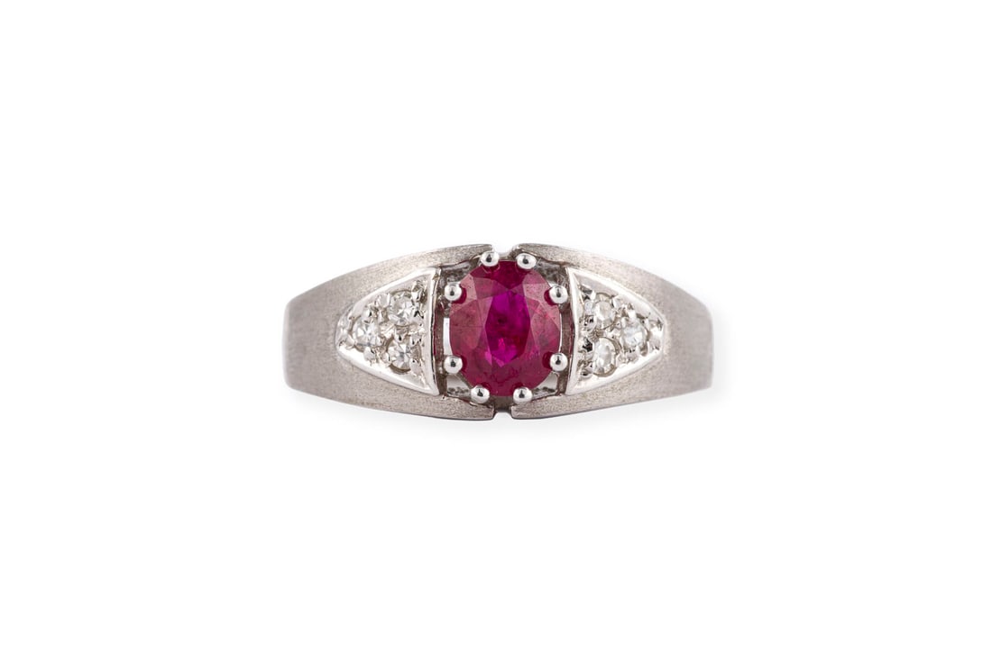 RUBIN BANDRING: RUBIN BANDRING WG 585. Ringmass: ca. 55. Ringbreite: ca. 7,9 mm. Ges.-Gew.: ca. 4,1 g. Ring, besetzt mit einem Rubin von ca. 0.65 ct. und 6 Diamanten im 8/8-Schliff zus. ca. 0.12 ct.