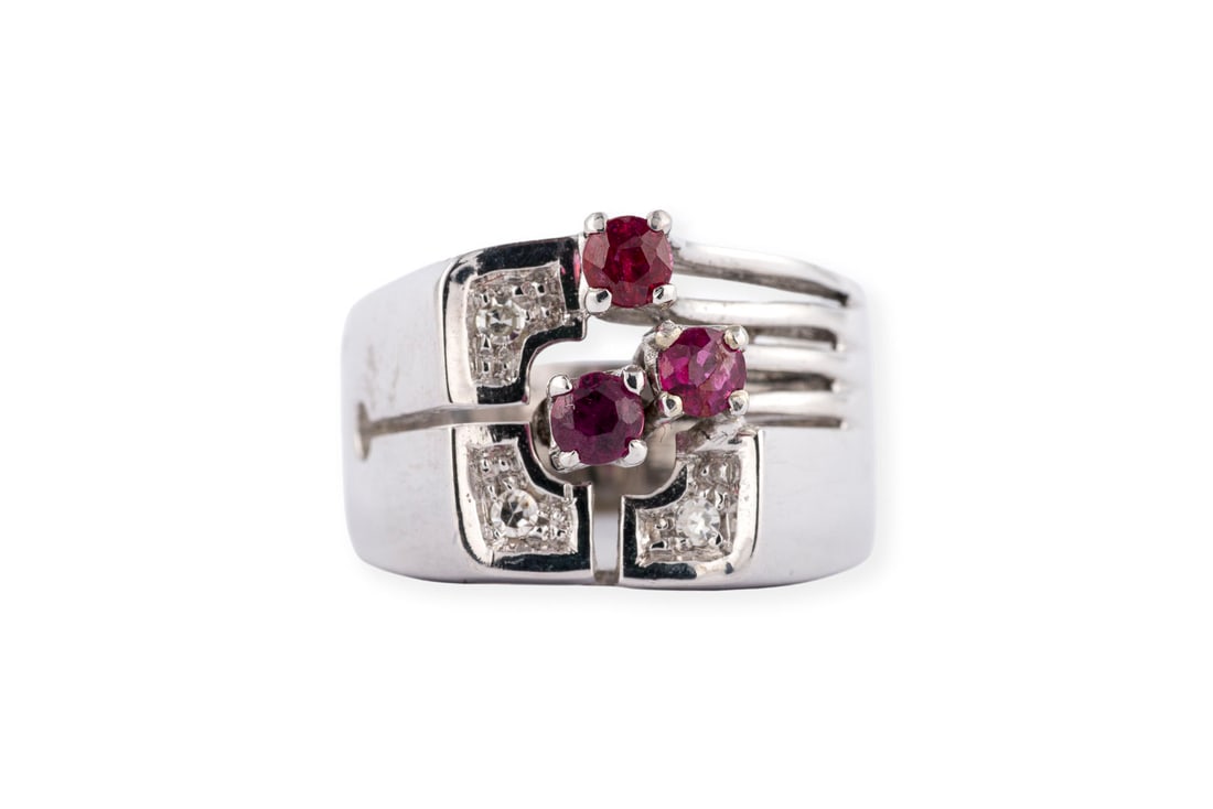DESIGN RUBIN RING: DESIGN RUBIN RING WG 750. Ringmass: ca. 54. Ringbreite: ca. 12,5 mm. Ges.-Gew.: ca. 7,5 g. Ring, besetzt mit 3 kleinen Rubinen und Diamanten im 8/8-Schliff zus. ca. 0.05 ct.