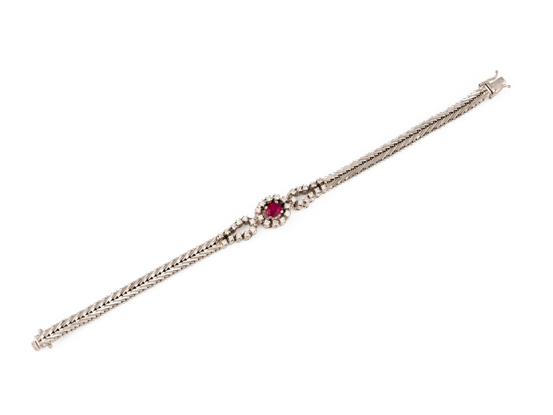 RUBIN BRILLANT ARMBAND: RUBIN BRILLANT ARMBAND WG 750. Masse: L.: ca. 18,5 cm, B.: ca. 11,5 mm. Ges.-Gew.: ca. 24,4 g. Armband, besetzt mit Brillanten zus. ca. 0.32 ct. G-I/VVS-P, sowie einem Rubin von ca. 0.68 ct.