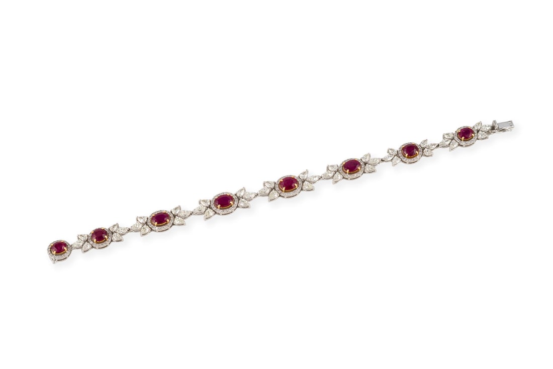 RUBIN ARMBAND: RUBIN ARMBAND WG 750. L.: 19,5 g. Ges.-Gew.: ca. 22,0 g. Gliederarmband, besetzt mit 8 Rubinen im Ovalschliff, zus. ca. 8.53 ct., umrahmt mit Diamanten im Brillant- und Marquiseschliff zus. ca. 6.97