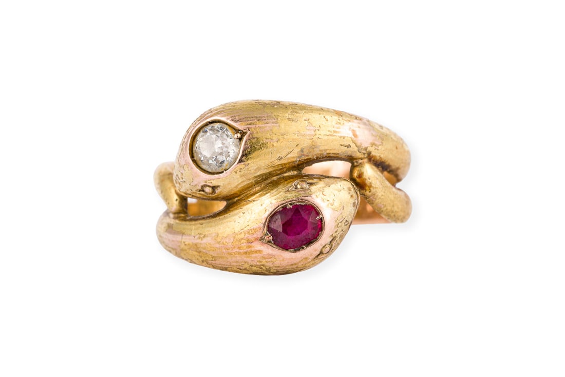 RUBIN SCHLANGEN RING: RUBIN SCHLANGEN RING GG 585. Ringmass: ca. 55. Ringbreite: ca. 14,2 mm. Ges.-Gew.: ca. 7,9 g. Ring in Form von zwei Schlangen, besetzt mit einem Rubin und einem Diamanten im Altschliff von ca. 0.25