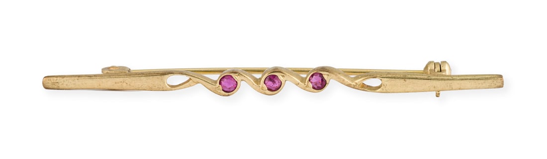 VOLUTEN BROSCHE: VOLUTEN BROSCHE GG 333. Masse: ca. 54,6 x 3,3 mm. Ges.-Gew.: ca. 1,8 g. Brosche bestehend aus volutenfoermigen Elementen, besetzt mit drei kleinen, rund facettierten roten Farbsteinen.