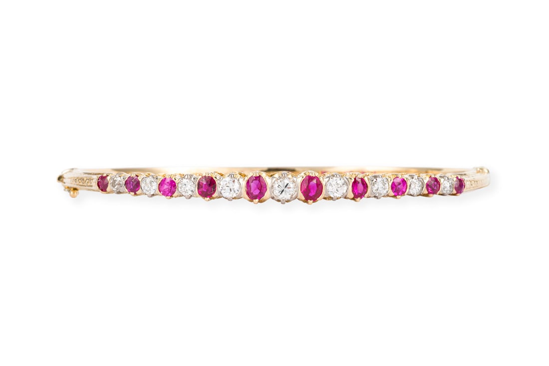 RUBIN BRILLANT ARMREIF: RUBIN BRILLANT ARMREIF GG 750. D.(innen): ca. 61,0 mm. B.: ca. 4,8 mm. Ges.-Gew.: ca. 18,7 g. Armreif, besetzt mit Rubinen zus. ca. 1.15 ct. und Altschliff-Diamanten zus. ca. 1.00 ct. H/VS-SI.