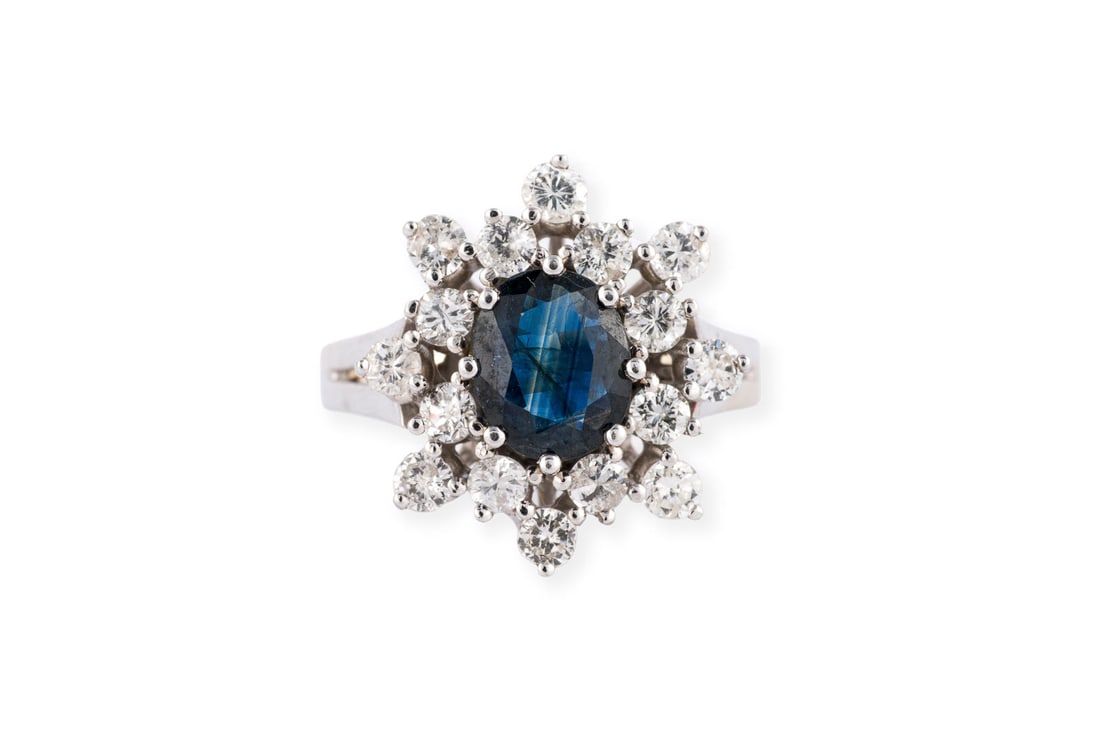 STERNFOERMIGER SAPHIR RING: STERNFOERMIGER SAPHIR RING WG 585. Ringmass: ca. 57. Ringkopfmasse: ca. 18,3 x 16,6 mm. Ges.-Gew.: ca. 5,2 g. Ring, besetzt mit einem zentralen Saphir von ca. 1.00 ct. und Brillantbesatz zus. ca.