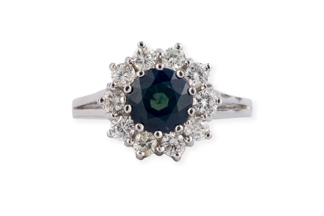 SAPHIR ENTOURAGE RING: SAPHIR ENTOURAGE RING WG 585. Ringmass: ca. 58. D.(Ringkopf): ca. 13,9 mm. Ges.-Gew.: ca. 5,6 g. Ring, besetzt mit einem zentralen Saphir von ca. 2.00 ct. und einem Kranz aus Brillanten zus. ca. 0.80