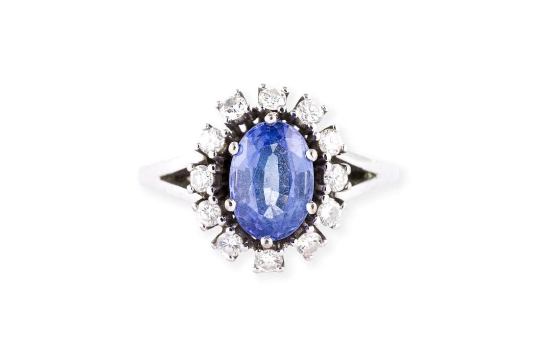OVALER TANSANIT ENTOURAGE RING: OVALER TANSANIT ENTOURAGE RING WG 585. Ringmass: ca. 56. Ringkopfmasse: ca. 14,1 x 12,3 mm. Ges.-Gew.: ca. 6,2 g. Ring, besetzt mit wohl einem zentralen Tansanit von ca. 1.42 ct. und einem Kranz aus