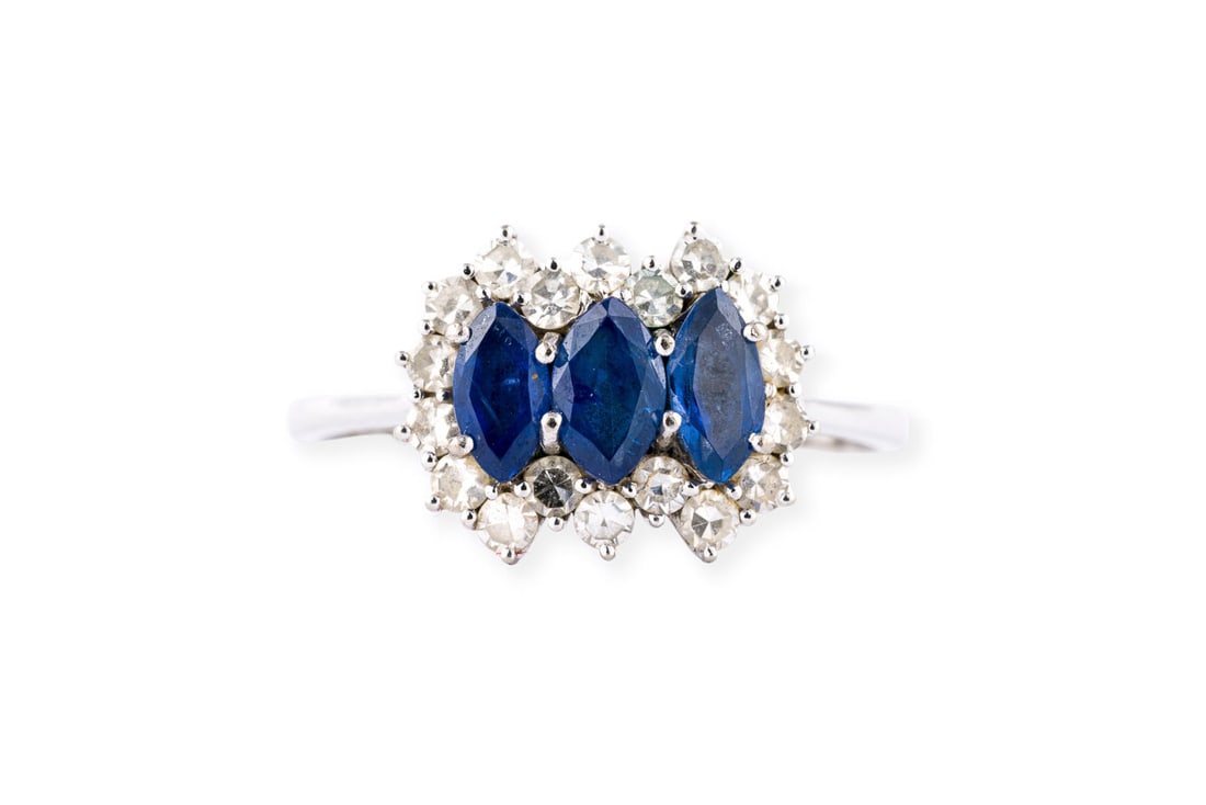 SAPHIR TRILOGIE RING: SAPHIR TRILOGIE RING WG 585 (getestet). Ringmass: ca. 56,5. Ringkopfmasse: ca. 13,2 x 10,6 mm. Ges.-Gew.: ca. 3,0 g. Ring, besetzt mit 3 Saphiren im Navetteschliff zus. ca. 0.60 ct. und einem Kranz