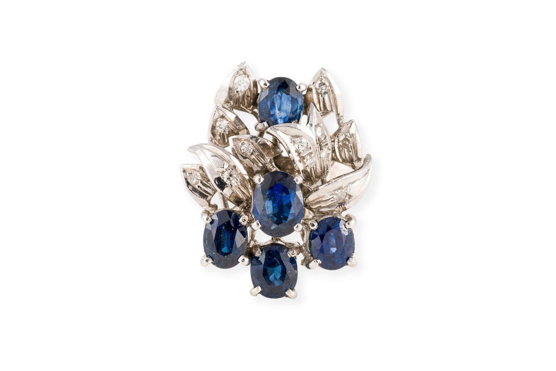 VERSPIELTER SAPHIR COCKTAIL RING: VERSPIELTER SAPHIR COCKTAIL RING WG 585. Ringmass: ca. 59. Ringkopfmasse: ca. 22,0 x 17,5 mm. Ges.-Gew.: ca. 8,6 g. Ring, besetzt mit Saphiren zus. ca. 3.50 ct. und Diamanten im 8/8-Schliff zus. ca.
