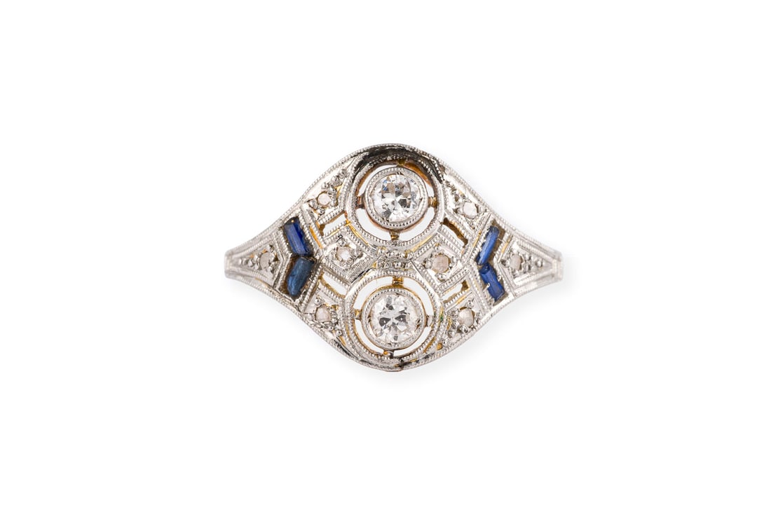ZIERVOLLER ART DECO RING: ZIERVOLLER ART DECO RING PT/GG 750 (getestet). Ringmass: ca. 51. Ringbreite: ca. 12,8 mm. Ges.-Gew.: ca. 2,4 g. Art DEco Ring, besetzt mit Diamanten zus. ca. 0.20 ct. und wohl synthetischen Saphiren.