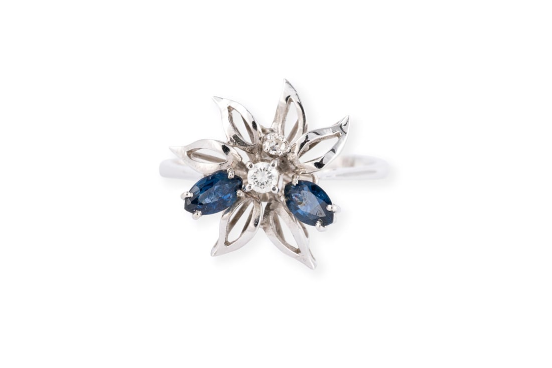 SAPHIR BLUETEN RING: SAPHIR BLUETEN RING WG 750. Ringmass: ca. 51,5. Ringbreite: ca. 15,0 mm. Ges.-Gew.: ca. 3,1 g. Ring, besetzt mit 2 Saphiren im Navetteschliff und 2 Brillanten zus. ca. 0.05 ct.