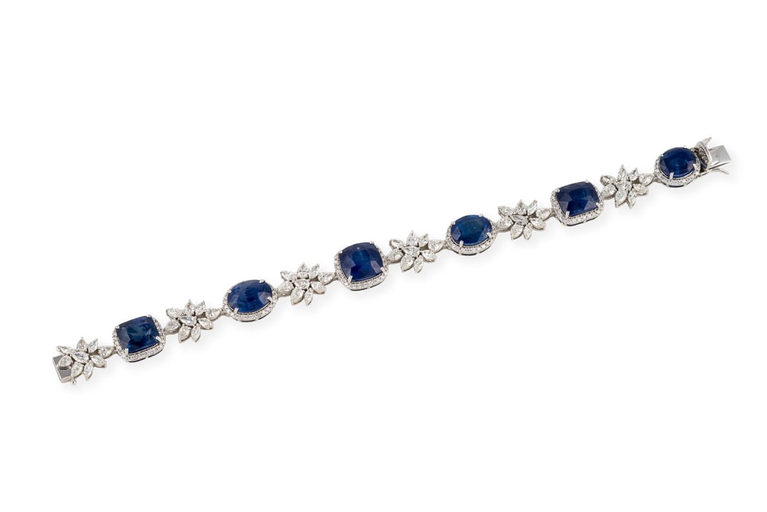 BEDEUTENDES SAPHIR ARMBAND: BEDEUTENDES SAPHIR ARMBAND WG 585. L.: ca. 18,5 cm. Ges.-Gew.: ca. 26,7 g. Armband, besetzt mit sechs ovalen und quadratischen Saphiren, zus. ca. 36.00 ct., die von Brillanten umgeben und durch