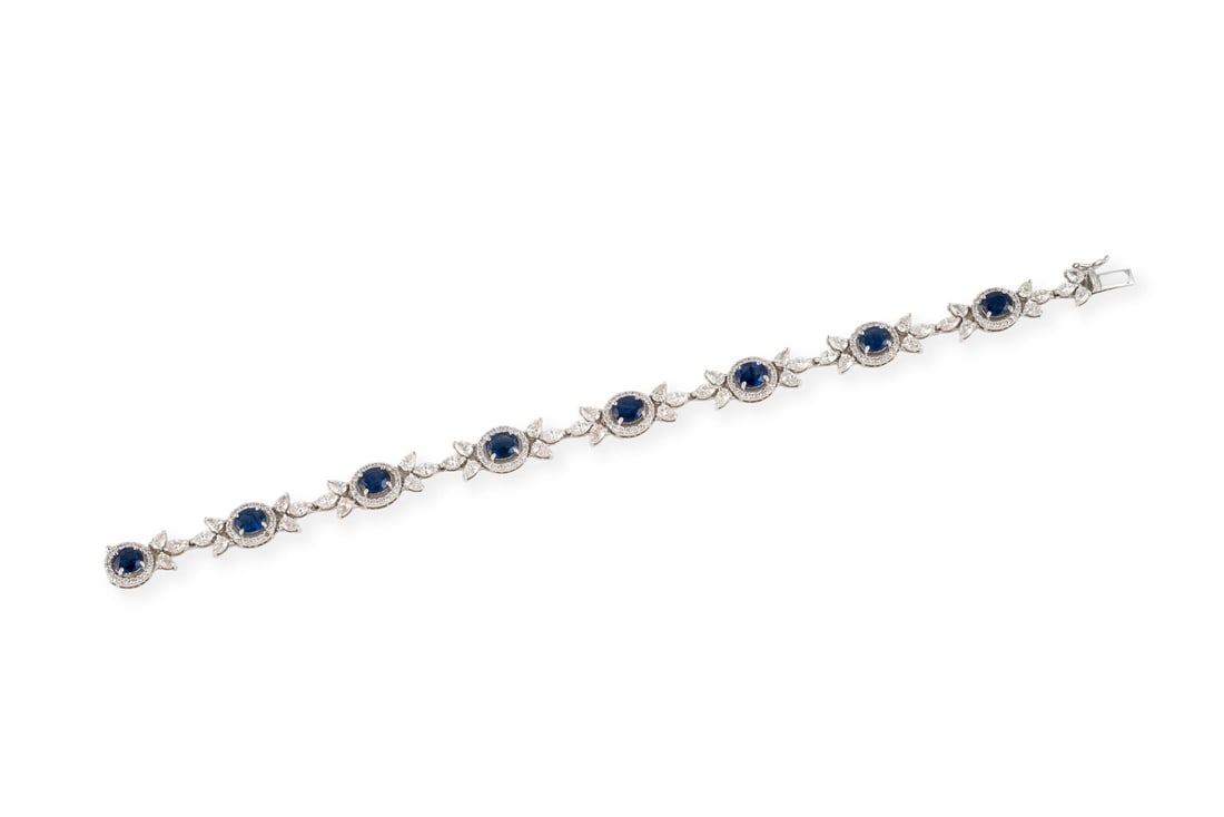 SAPHIR ARMBAND: SAPHIR ARMBAND WG 750. L.: ca. 19,0 cm. Ges.-Gew.: ca. 17,5. Gliederarmband, besetzt mit 8 Saphiren im Ovalschliff, zus. ca. 6.25 ct., umrahmt mit Diamanten im Brillant-, Tropfen- und Marquiseschliff