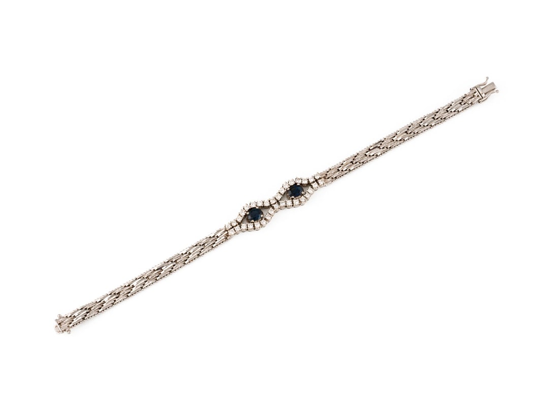 SAPHIR BRILLANT ARMBAND: SAPHIR BRILLANT ARMBAND WG 750 (getestet). Masse: L.: ca. 18,5 cm. B.: ca. 10,7 mm. Ges.-Gew.: ca. 25,8 g. Armband, besetzt mit Brillanten zus. ca. 1.02 ct. H-I/VVS-P, sowie 5 Saphiren ? 0.50 ct.