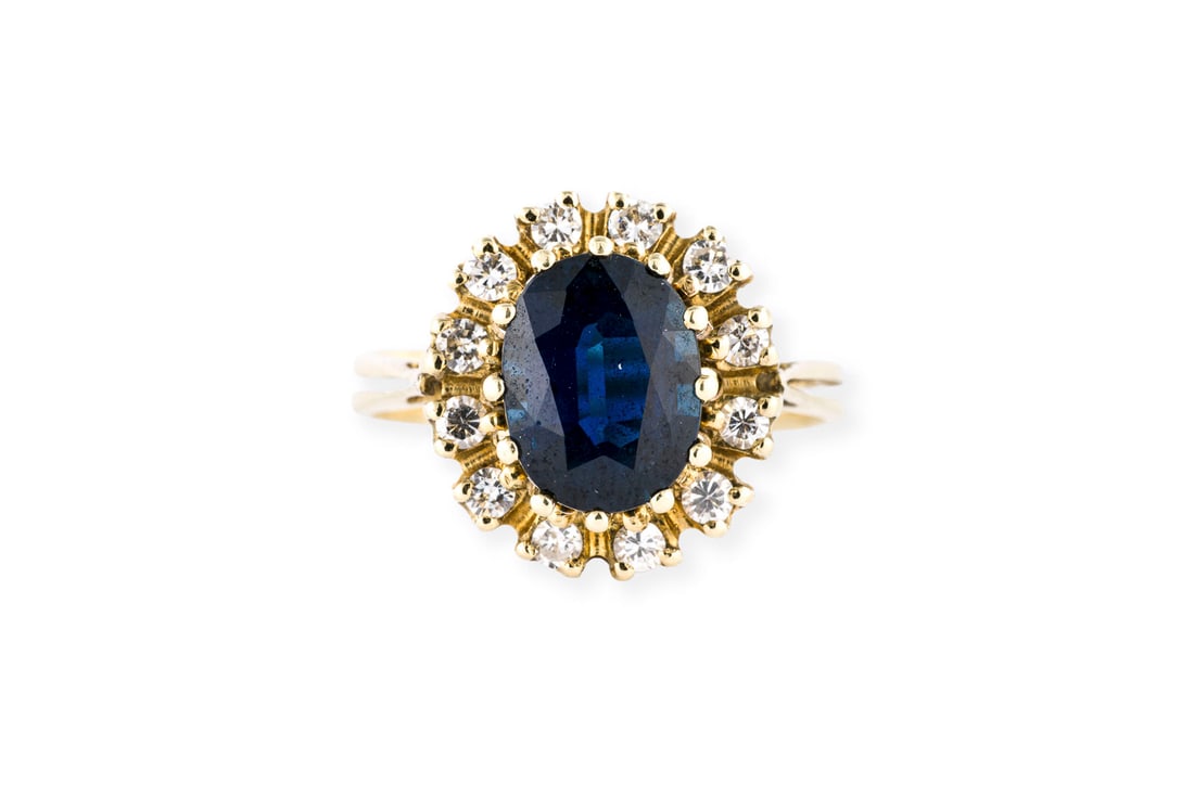 SAPHIR ENTOURAGE RING: SAPHIR ENTOURAGE RING GG 585. Ringmass: ca. 52. Ringkopfmasse: ca. 14,0 x 13,0 mm. Ges.-Gew.: ca. 4,0 g. Ring, besetzt mit einem zentralen Saphir von ca. 1.85 ct. und einem Kranz aus Brillanten zus. c