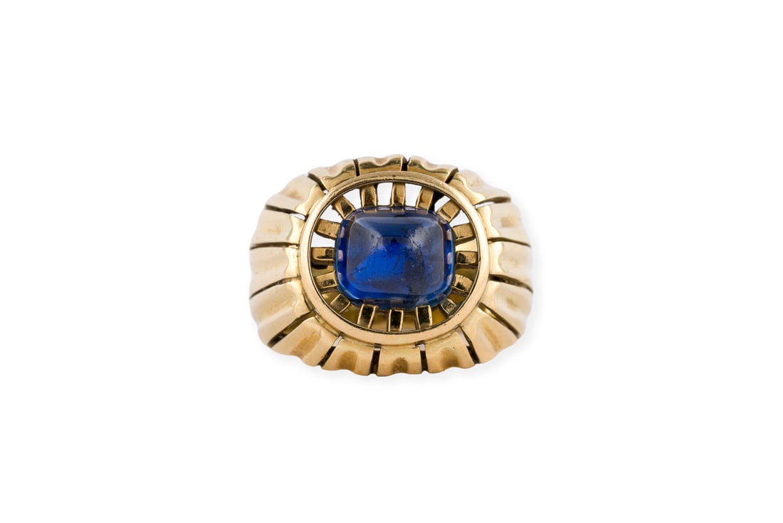 BREITER STRUKTURIERTER RING: BREITER STRUKTURIERTER RING GG 750. Ringmass: ca. 54. Ringbreite: ca. 15,5 mm. Ges.-Gew.: ca. 10,0 g. Ring, besetzt mit einem blauen Farbstein-Cabochon - wohl synthetischer Saphir.