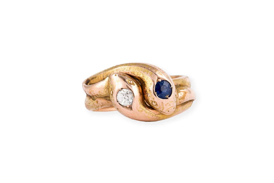 SAPHIR SCHLANGEN RING: SAPHIR SCHLANGEN RING GG 585. Ringmass: ca. 54. Ringbreite: ca. 11,0 mm. Ges.-Gew.: ca. 8,2 g. Ring, in Form von zwei Schlangen, besetzt mit einem Saphir und einem Diamanten im Altschliff von ca.