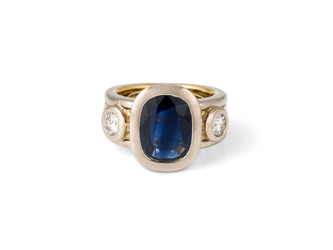 MASSIVER SAPHIR RING: MASSIVER SAPHIR RING WG/GG 750 (getestet). Ringmass: ca. 55. Ringkopfmasse: ca. 16,6 mm x 13,6 mm. Ges.-Gew.: ca. 23,8 g. Massiver Ring mit einem zentralen Saphir von ca. 3.80 ct. und zwei Brillanten 