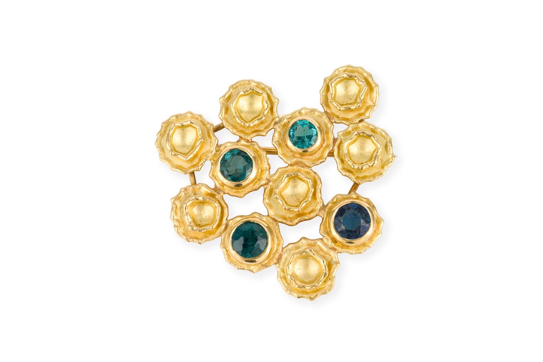 DESIGN BROSCHE: DESIGN BROSCHE GG 750. Masse: ca. 28,5 x 29,0 mm. Ges.-Gew.: ca. 5,3 g. Designbrosche, besetzt mit 4 rund facettierten, blauen Farbsteinen.