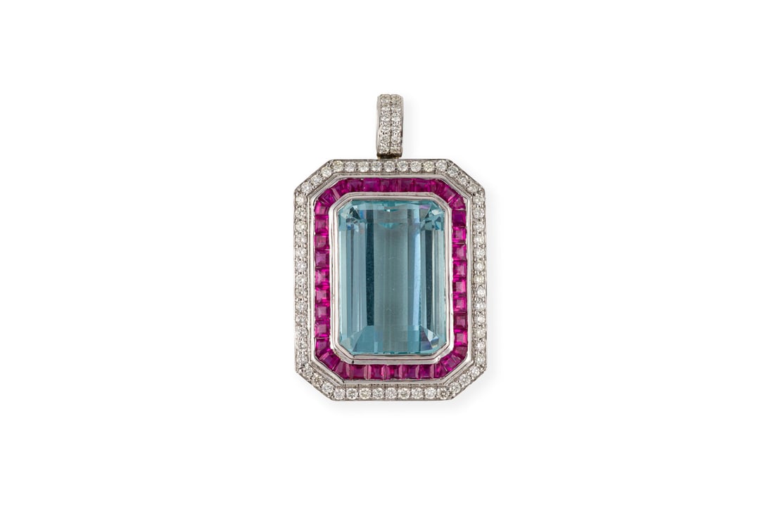 AQUAMARIN ANHAENGER: AQUAMARIN ANHAENGER WG 750. L.: ca, 39,0 mm. Ges.-Gew.: ca. 13,4 g. Atemberaubender Aquamarin von ca. 24.18 ct., umgeben von Rubinen und Brillanten zus. ca. 0.95 ct.