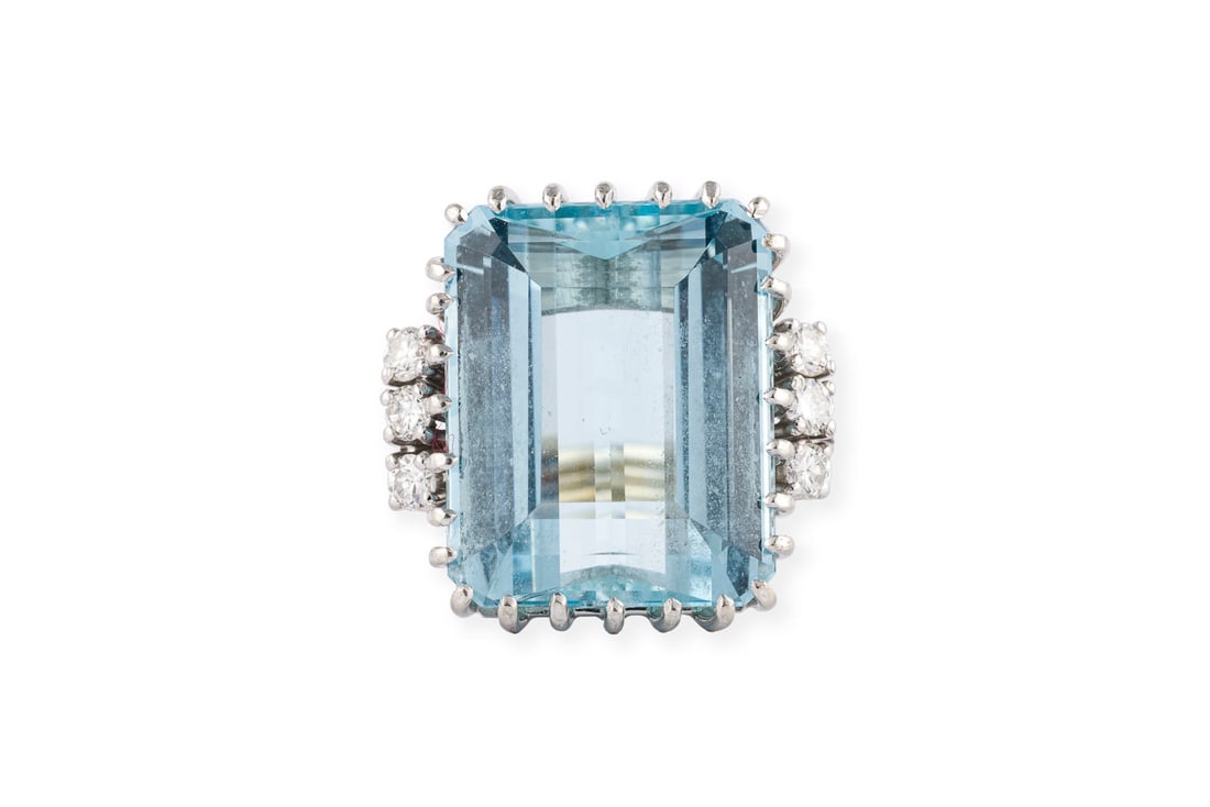 GROssER AQUAMARIN RING 15.00 CT.: GROssER AQUAMARIN RING 15.00 CT. WG 750. Ringmass: ca. 61. Ringkopfmasse: ca. 20,0 x 20,2 mm. Ges.-Gew.: ca. 11,6 g. Ring, besetzt mit einem Aquamarin von ca. 15.00 ct., flankiert von Brillanten zus.