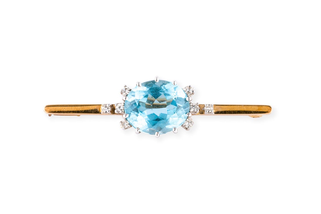 BLAUTOPAS STABBROSCHE: BLAUTOPAS STABBROSCHE GG 585. Masse: ca. 51,1 x 13,8 mm. Ges.-Gew.: ca. 7,8 g. Stabbrosche, besetzt mit einem Blautopas von ca. 8.89 ct. und Diamanten im 8/8-Schliff zus. ca. 0.20 ct.